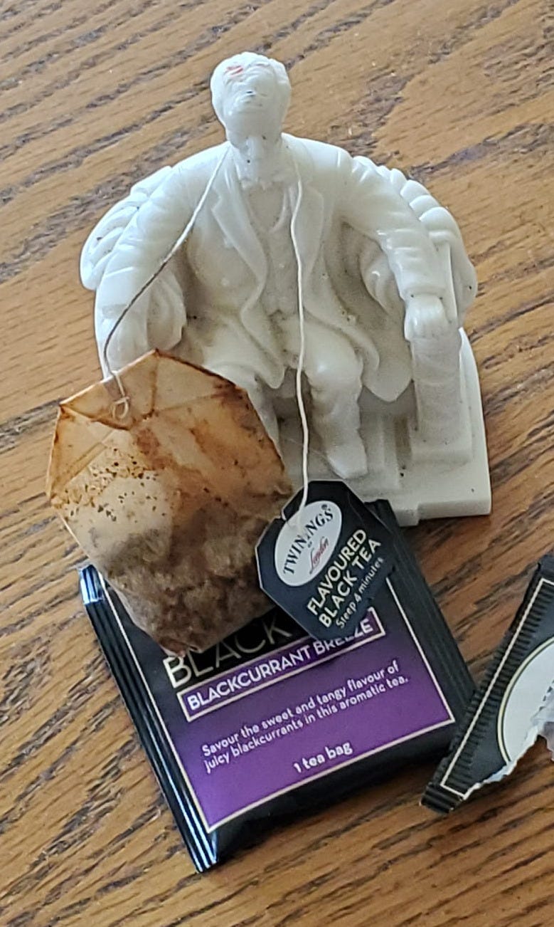 Image of Lincoln Statue from Memorial with a tea bag string around his neck.