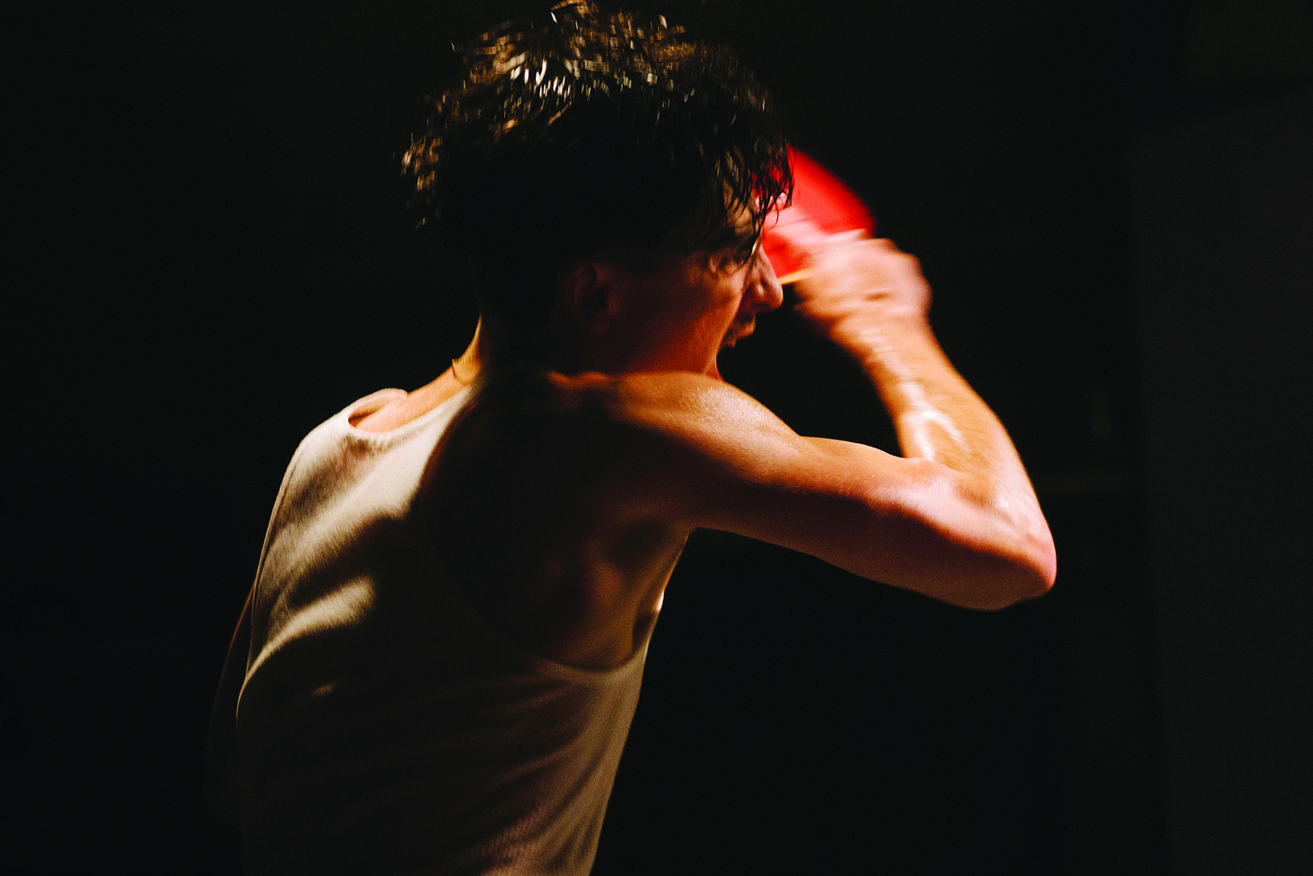 Movie still from Marty Supreme. A young man plays pingpong, sweating