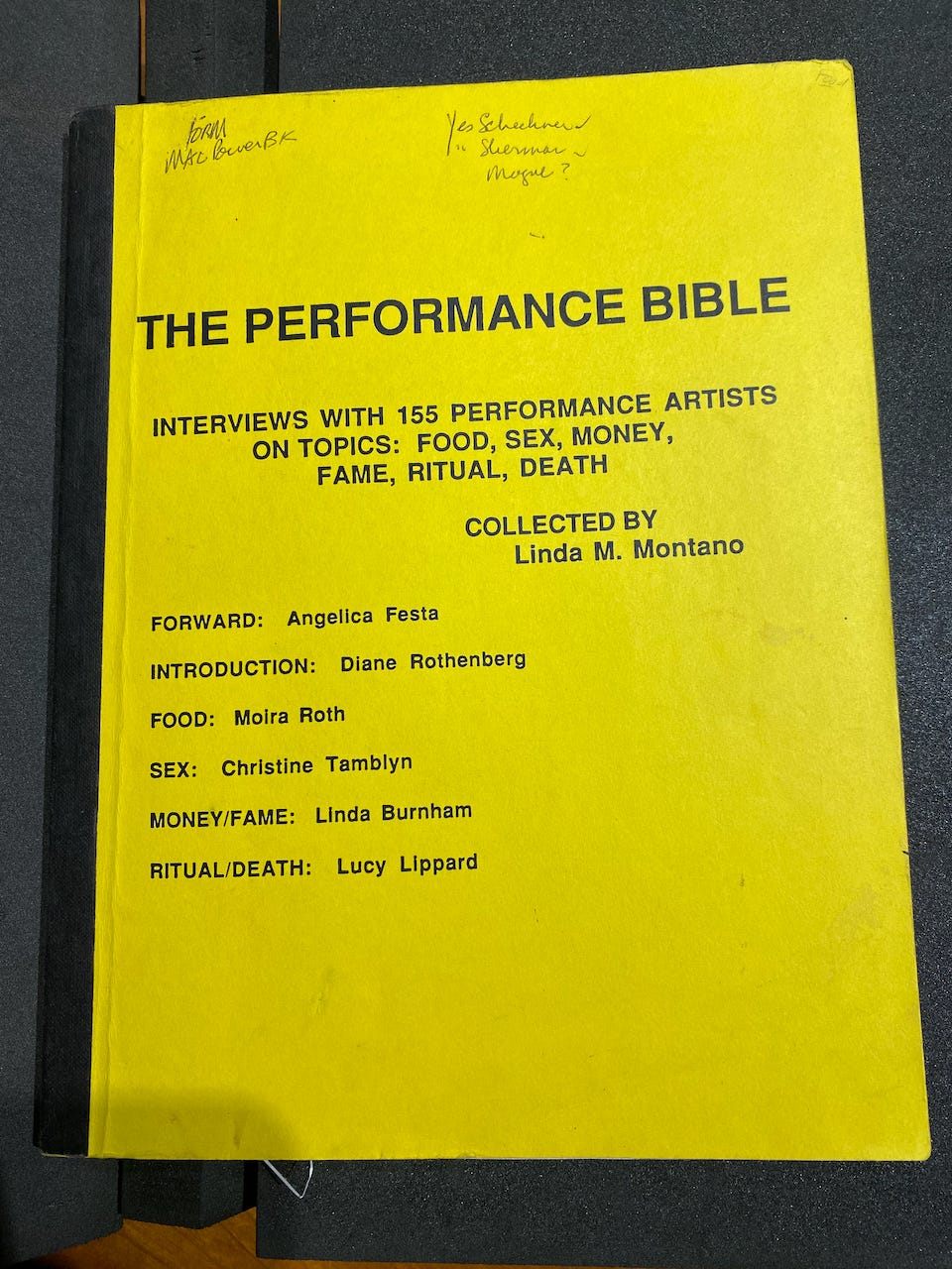 A yellow perfect bound book, the proof to Linda Montano's Performance Bible