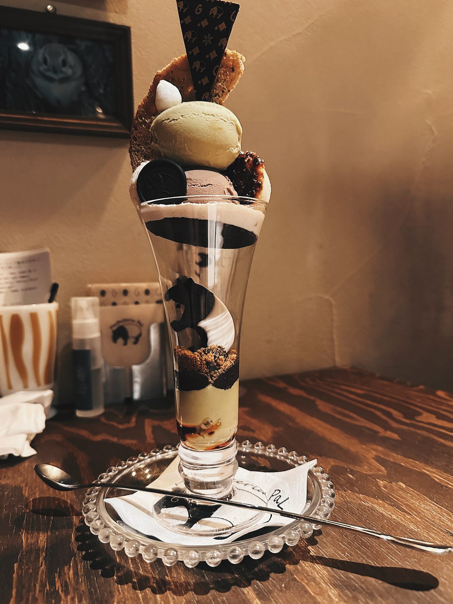 Tall layered parfait with matcha ice cream, chocolate wafer, and structured interior visible through the glass at Parfaiteria Pal in Sapporo, Japan. Tall layered parfait with matcha ice cream, chocolate wafer, and structured interior visible through the glass at Parfaiteria Pal in Sapporo, Japan.