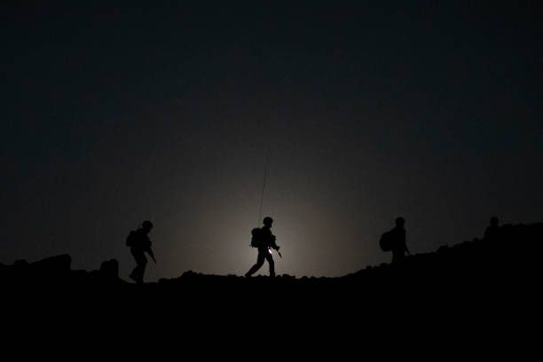 Personnel from 40 Commando, Royal Marines walk across a ridge with the moon setting behind during exercise 'Saif Sareea 3' on October 24, 2018 in...