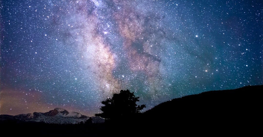 silhouette of trees and mountain under blue sky at nighttime