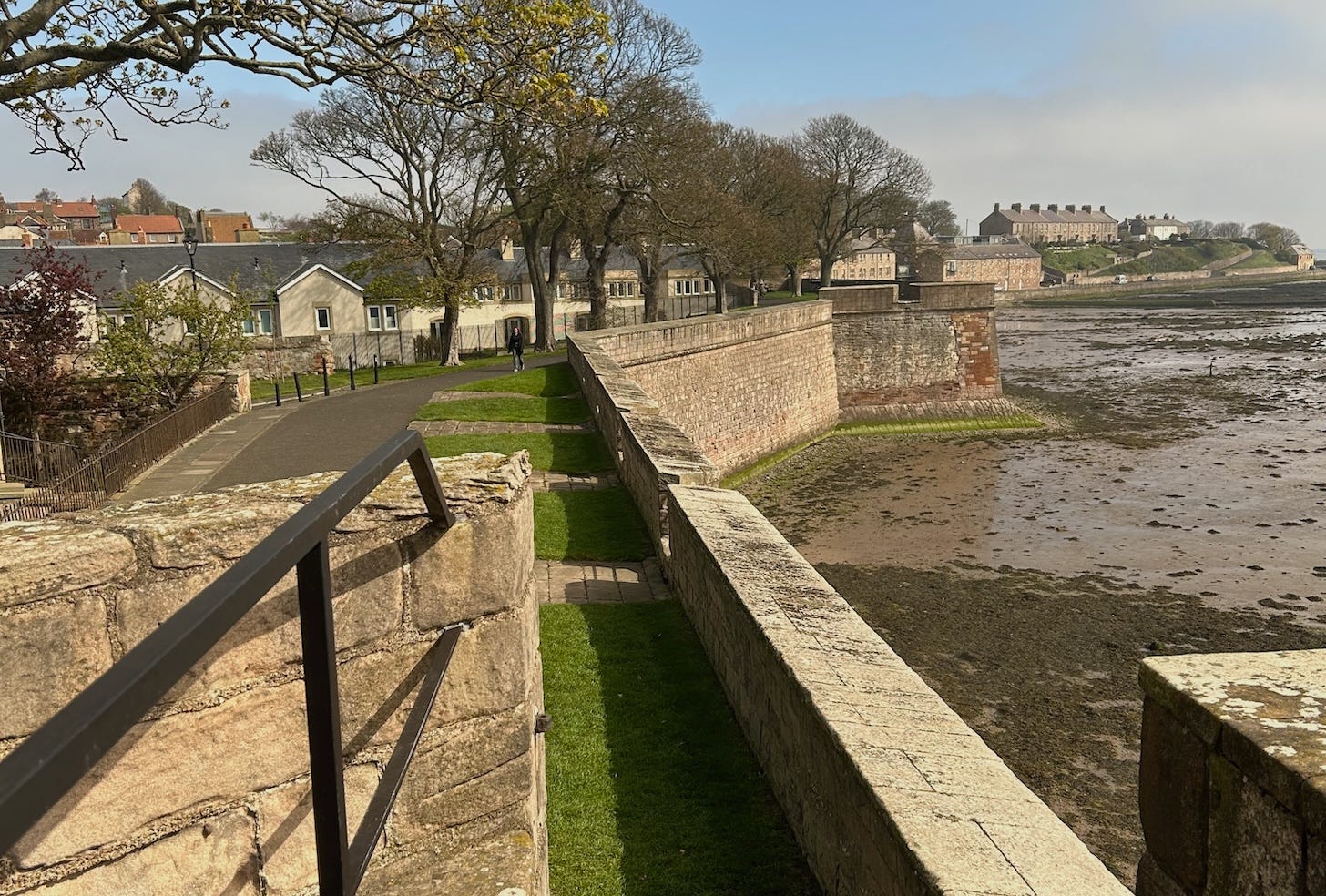 landscape view of old walls a walkway and houses in the distance with the a river estuary to the right. this is Berwick upon Tweed landscape view of old walls a walkway and houses in the distance with the a river estuary to the right. this is Berwick upon Tweed