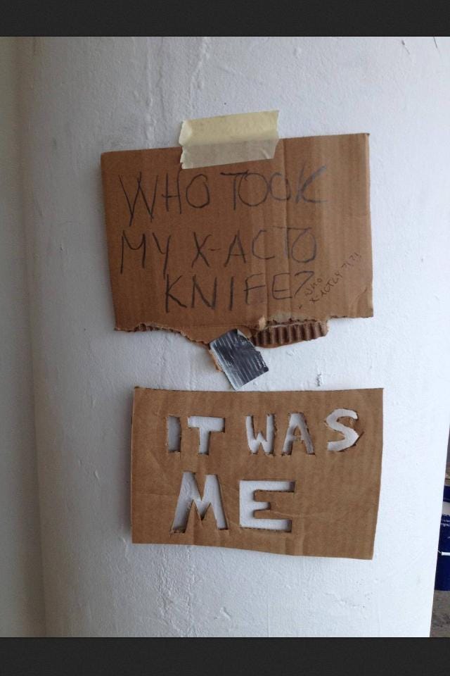 A cardboard sign that reads who took my xacto knife? with a cardboard sign below it that reads IT WAS ME with the letters carved out of the cardboard using an xacto knife A cardboard sign that reads who took my xacto knife? with a cardboard sign below it that reads IT WAS ME with the letters carved out of the cardboard using an xacto knife