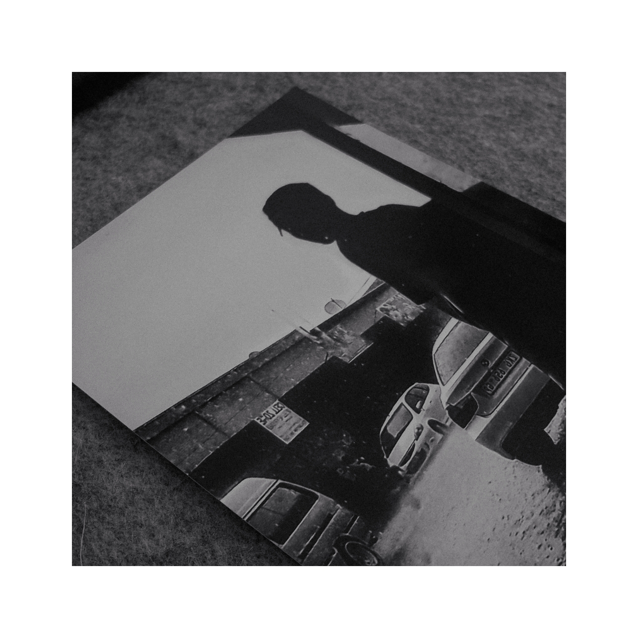 A photo of a photo. A man waiting for the rain to pass.
