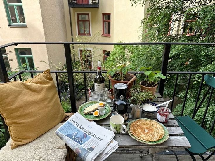 This may contain: an outdoor table with breakfast food and drinks on it in front of a balcony overlooking the city This may contain: an outdoor table with breakfast food and drinks on it in front of a balcony overlooking the city