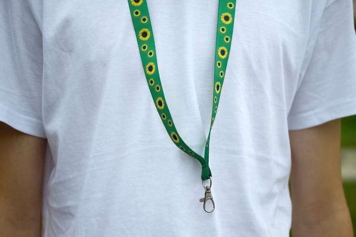 Man in white T-Shirt with a sunflower lanyard