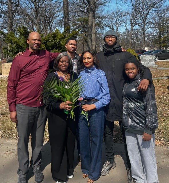 A group photo of Khalil, his mother Anita, his father, his fiancée, his younger brother, and sister standing together at a family gathering in Detroit.