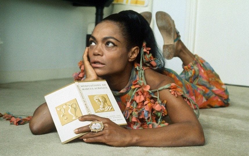 Eartha Kitt lies on the floor reading "Meditations of Marcus Aurelius"
