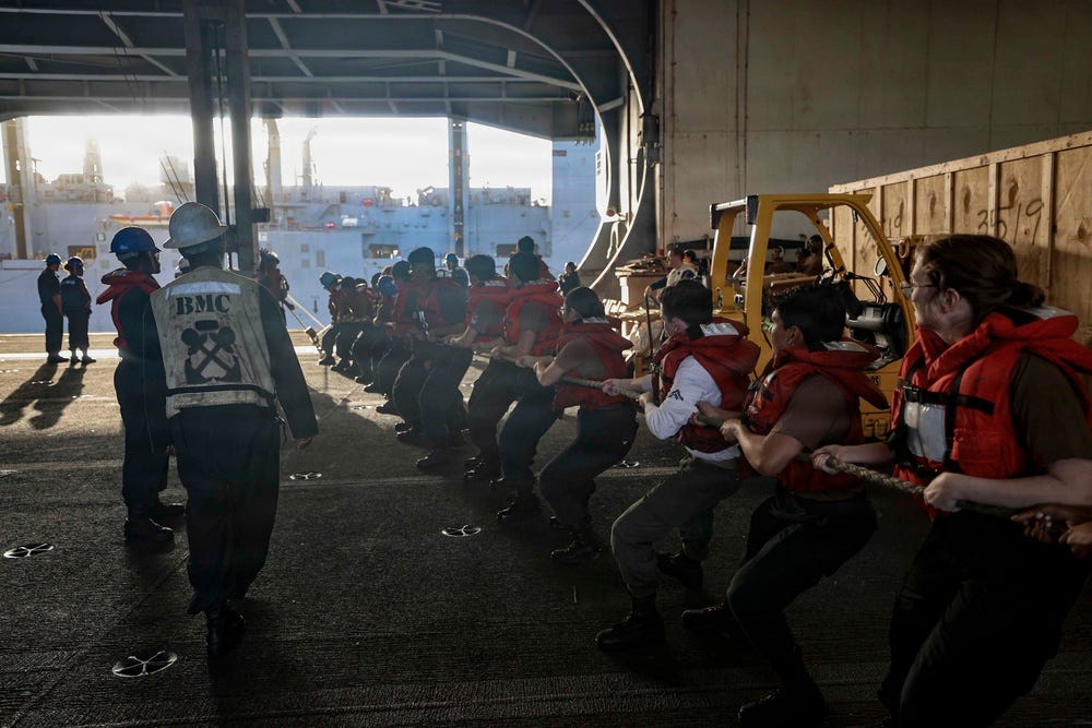 U.S. Sailors assigned to USS Abraham Lincoln conduct line handling during replenishment at sea on February 18, 2026.