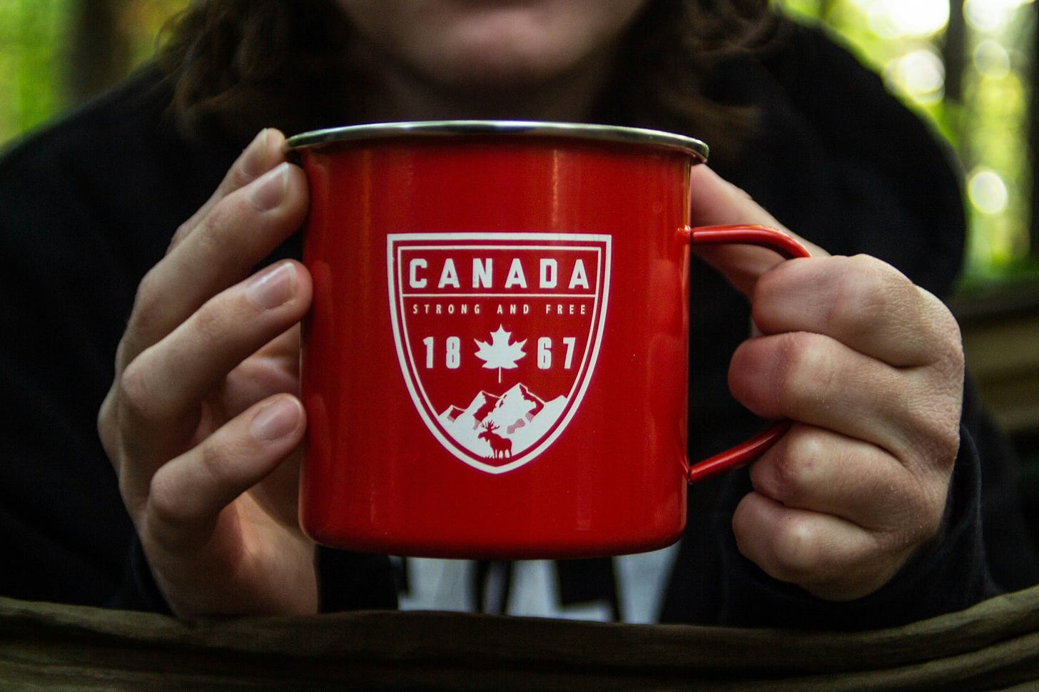 person holding red metal mug person holding red metal mug