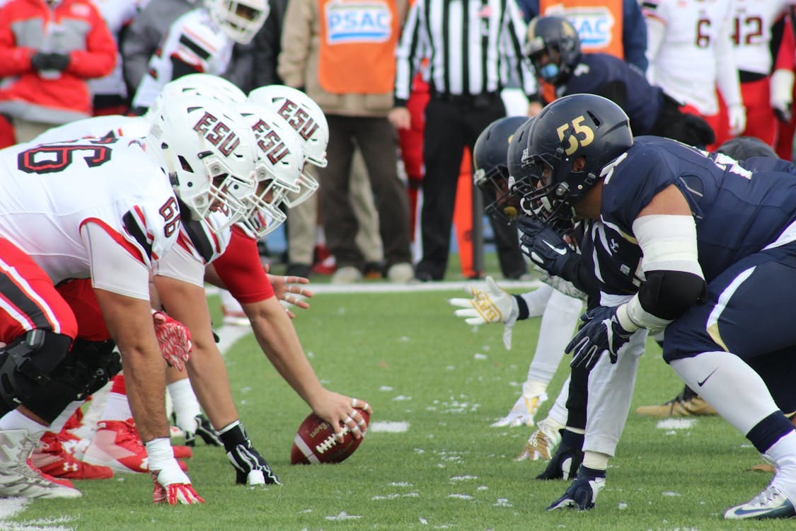 Free Rival football teams face off at the start of an action-packed game on the field. Stock Photo