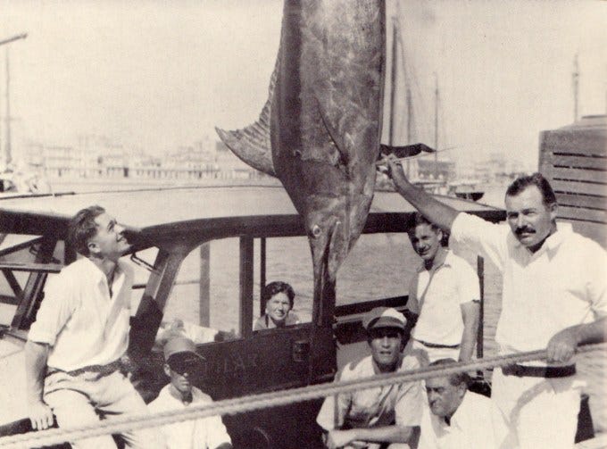 Hemingway shows off a 324-pound blue marlin as Samuelson (far left) admires it.