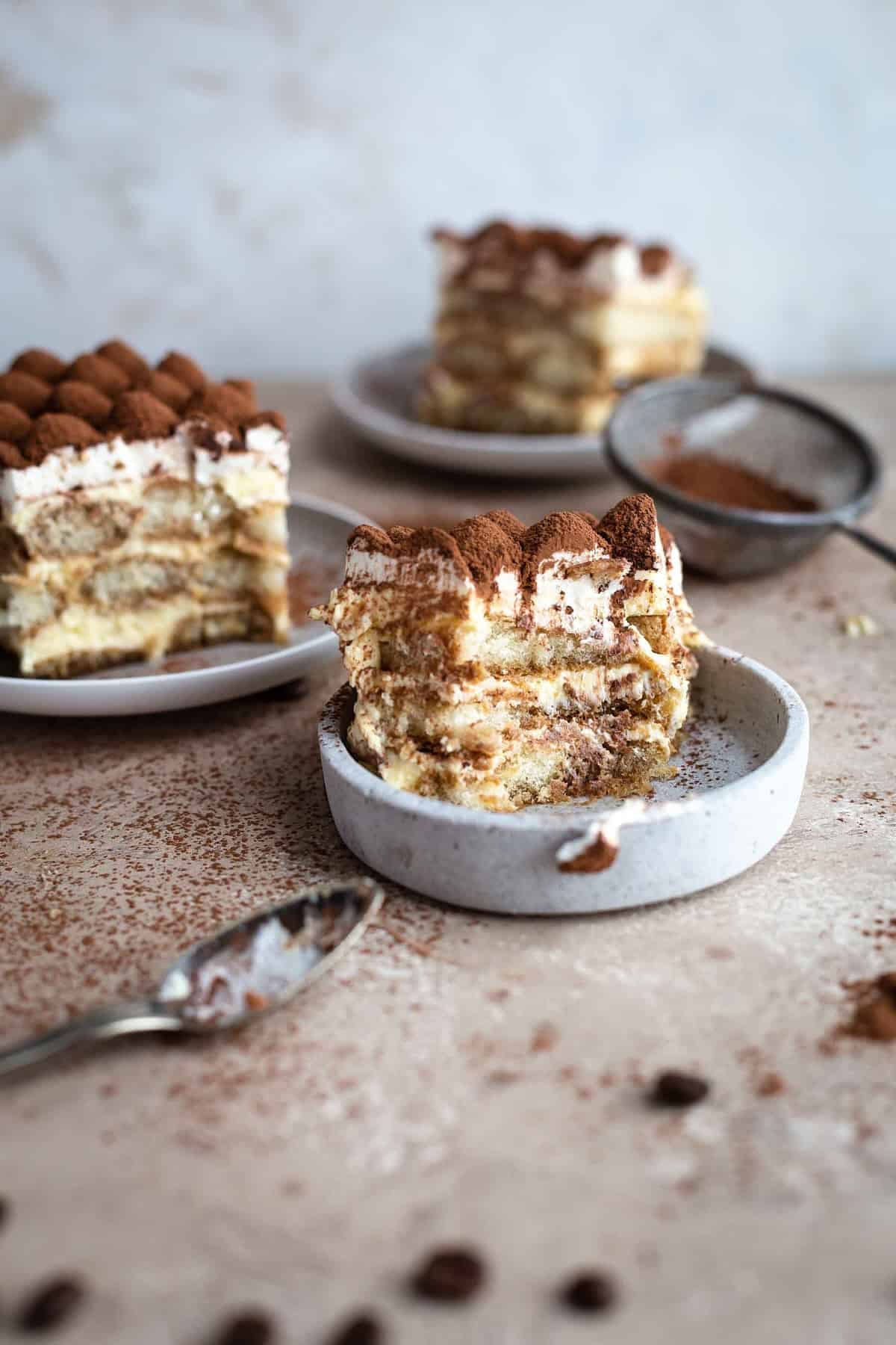 Decorative picture of half eaten tiramisu on grey plates