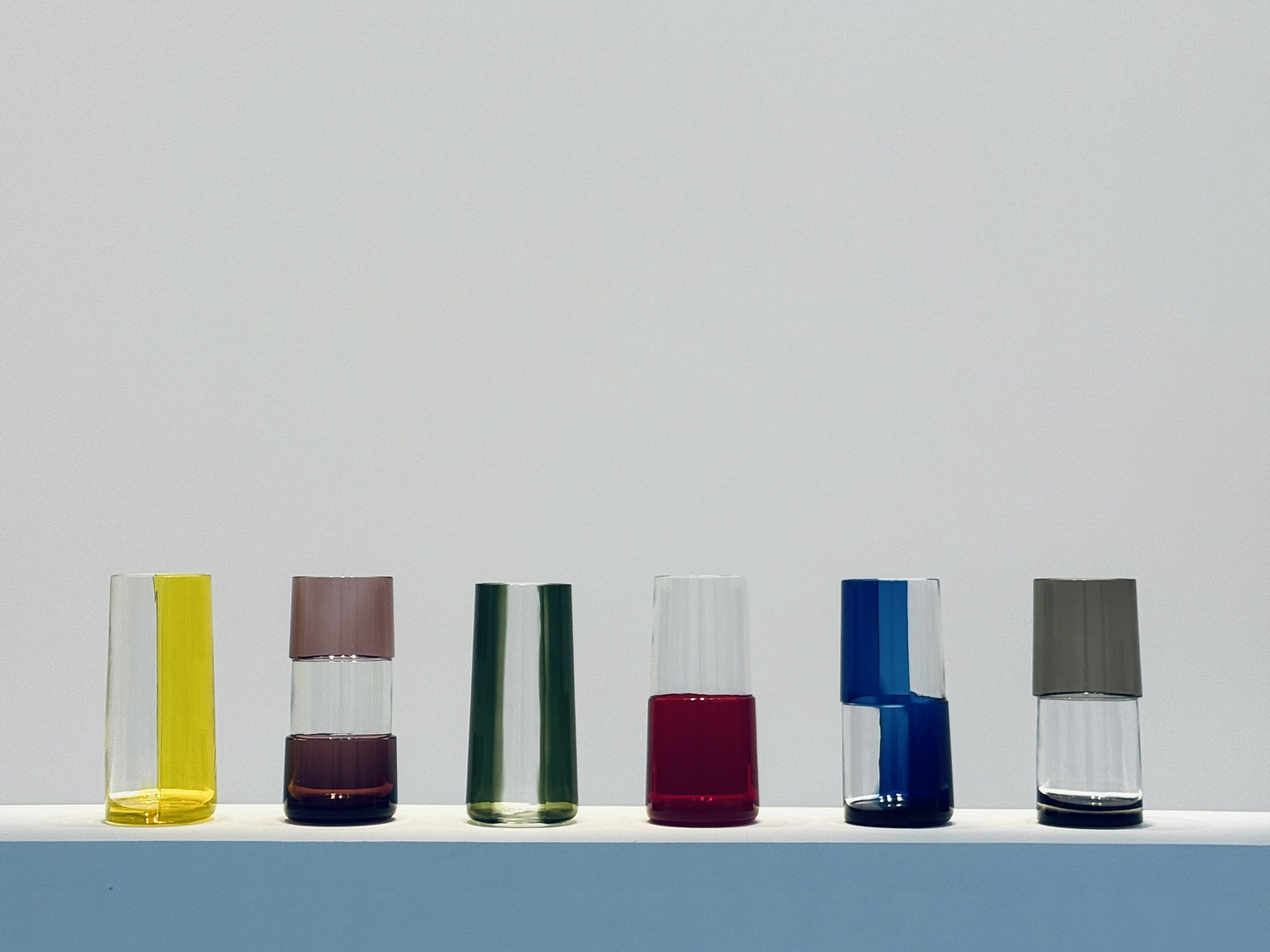 Six hand blown glasses with various colors on a table
