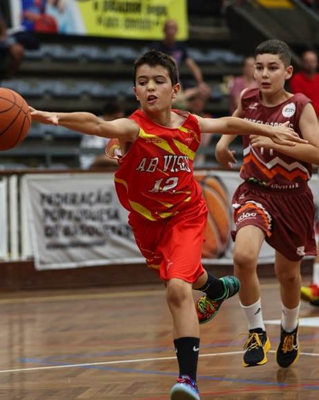 Pode ser uma imagem de 2 pessoas, pessoas a jogar basquetebol e a texto