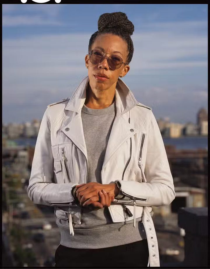 1) A person with a confident expression poses against a white background. They wear a maroon vest with an intricate trim, black pants, and they have styled hair. Tattoos adorn their arms, and they hold a beaded necklace near their face. Their vest is open, revealing their bare chest, and they are staring straight into the camera. 2) A person with sunglasses and braided hair stands confidently on a rooftop, wearing a white leather jacket and gray sweater. The background shows a skyline under a clear sky. They are holding their hands together in front of their torso, and they are staring straight into the camera with a neutral expression.