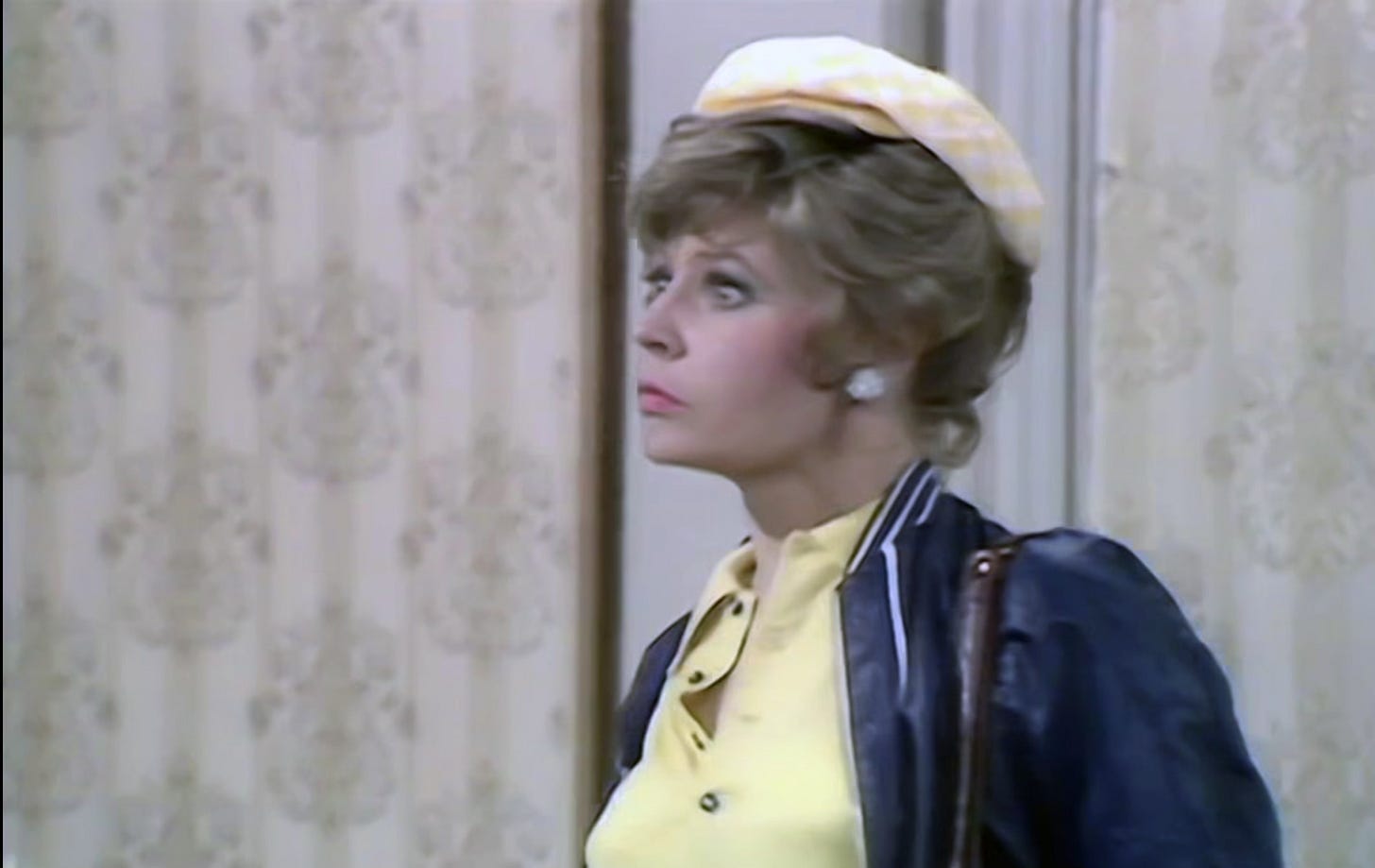 Sybil Fawlty in a yellow cap looking horrified