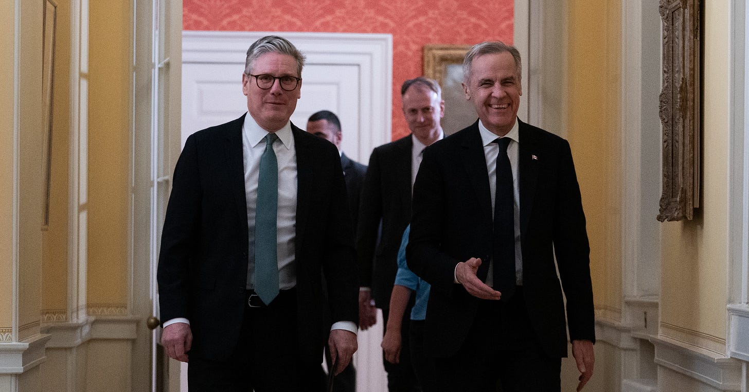 Prime Minister Mark Carney and the Prime Minister of the United Kingdom, Sir Keir Starmer, walk together down a narrow corridor in 10 Downing Street in London, England. Prime Minister Mark Carney and the Prime Minister of the United Kingdom, Sir Keir Starmer, walk together down a narrow corridor in 10 Downing Street in London, England.