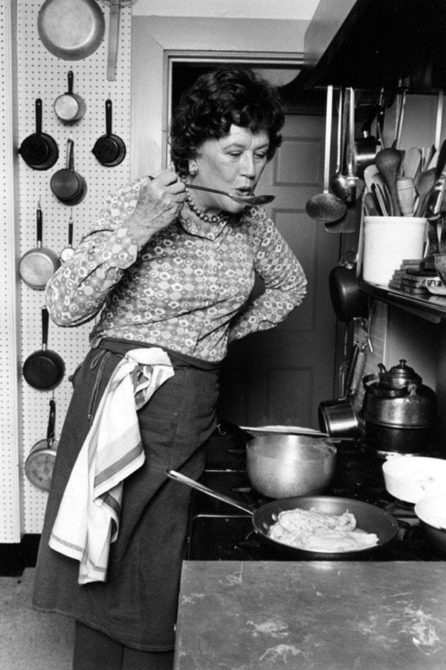 This may contain: an old black and white photo of a woman cooking