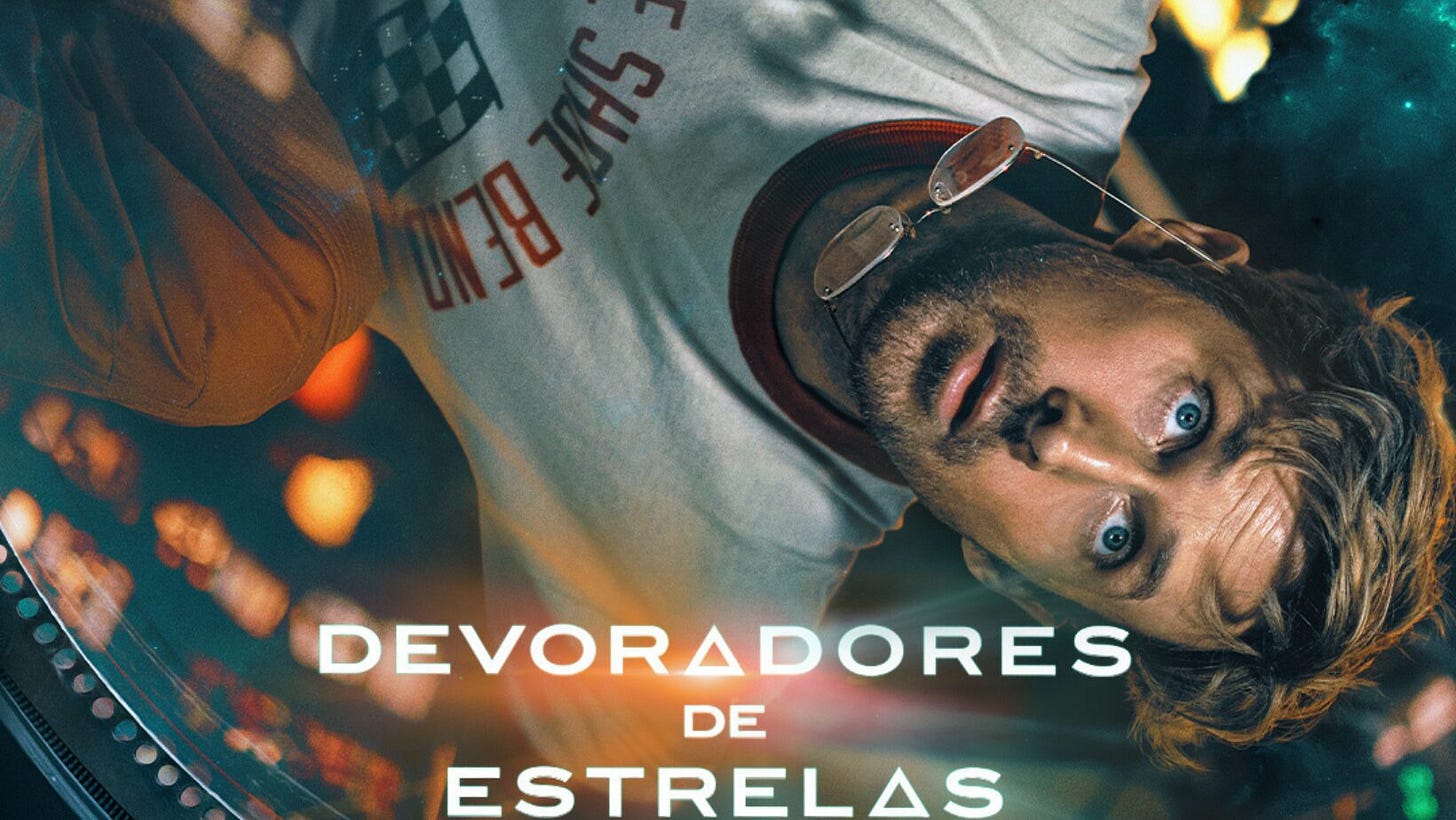 Pôster do filme 'Devoradores de Estrelas' com um homem de cabelo loiro e óculos, deitado e olhando para a câmera, cercado por elementos cósmicos.
