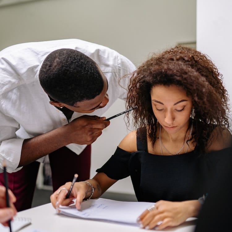 Free A Man Pointing a Pencil to a Woman Stock Photo