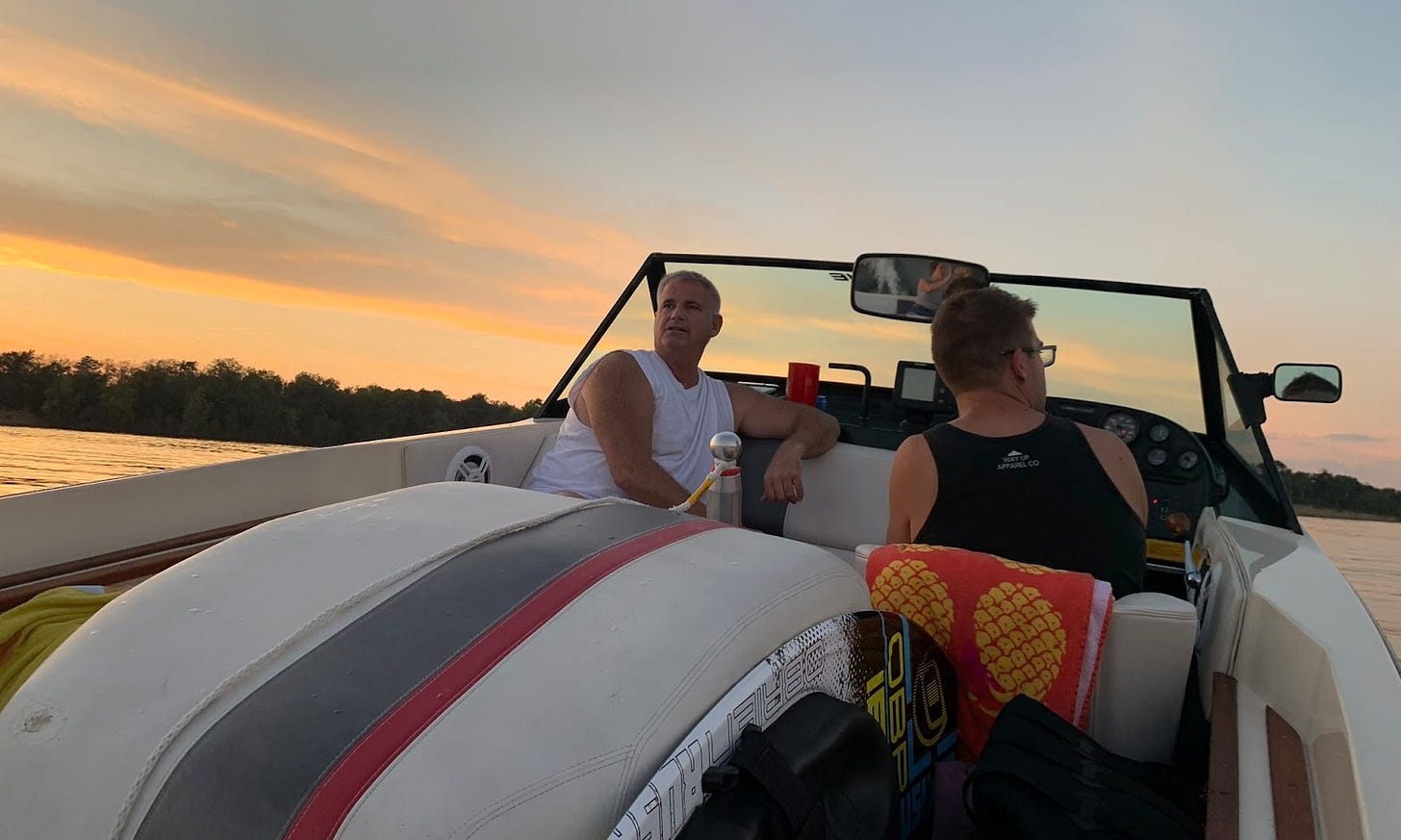 Man rides in a classic MasterCraft ski boat at sunset, gliding toward the horizon, capturing a heartfelt moment of reflection and legacy as Uncle Eddie enjoys the water that shaped his family’s traditions and joy.