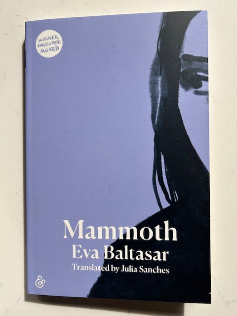 A lavender book cover with a drawing of a woman's profile on the right. Text reads Mammoth Eva Baltasar. A lavender book cover with a drawing of a woman's profile on the right. Text reads Mammoth Eva Baltasar.