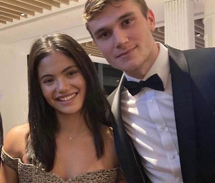 This may contain: a man in a tuxedo standing next to a woman