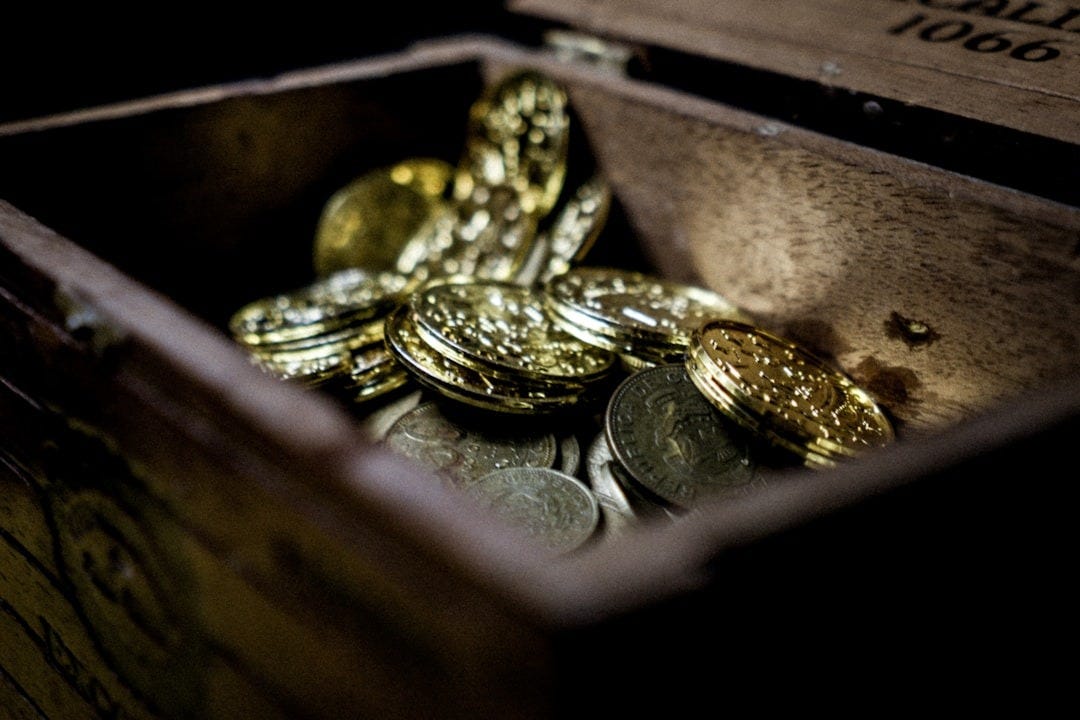 a wooden box filled with lots of coins a wooden box filled with lots of coins