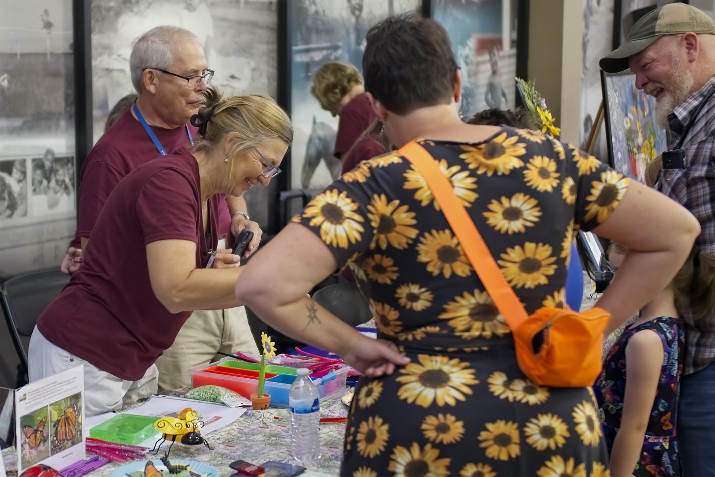Master Gardeners lead a family in a monarch butterfly bracelet craft.