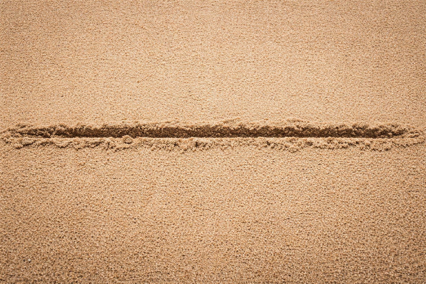 A stark, close-up view of a single straight line drawn deeply across smooth, undisturbed sand, dividing the frame cleanly in two. The sand is evenly textured with no footprints or objects visible, emphasizing a clear boundary and the sense of a firm, deliberate line that should not be crossed. A stark, close-up view of a single straight line drawn deeply across smooth, undisturbed sand, dividing the frame cleanly in two. The sand is evenly textured with no footprints or objects visible, emphasizing a clear boundary and the sense of a firm, deliberate line that should not be crossed.
