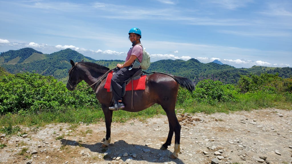 A tourist enjoying a horse ride in Costa Rica A tourist enjoying a horse ride in Costa Rica