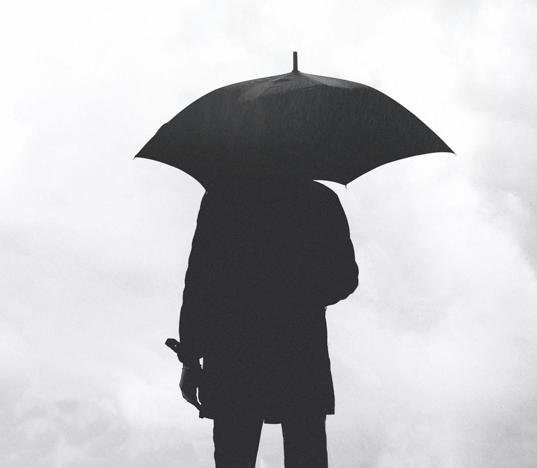 silhouette of person under umbrella under cloudy sky silhouette of person under umbrella under cloudy sky