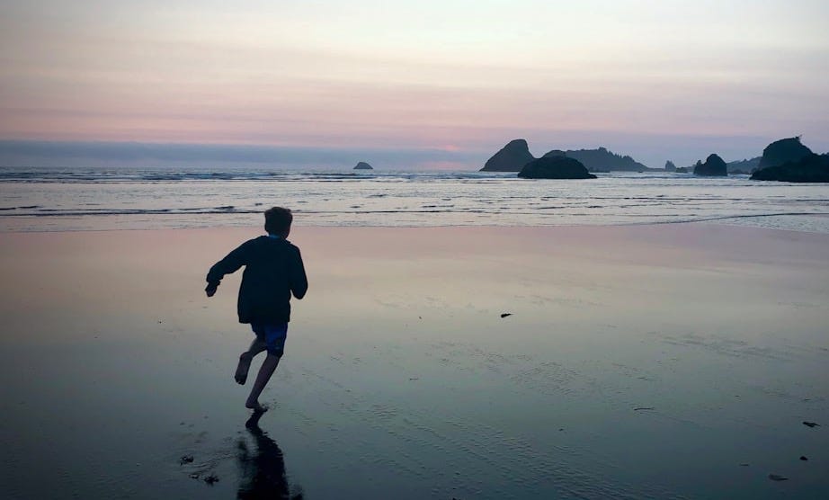 a person running on a beach near the ocean a person running on a beach near the ocean