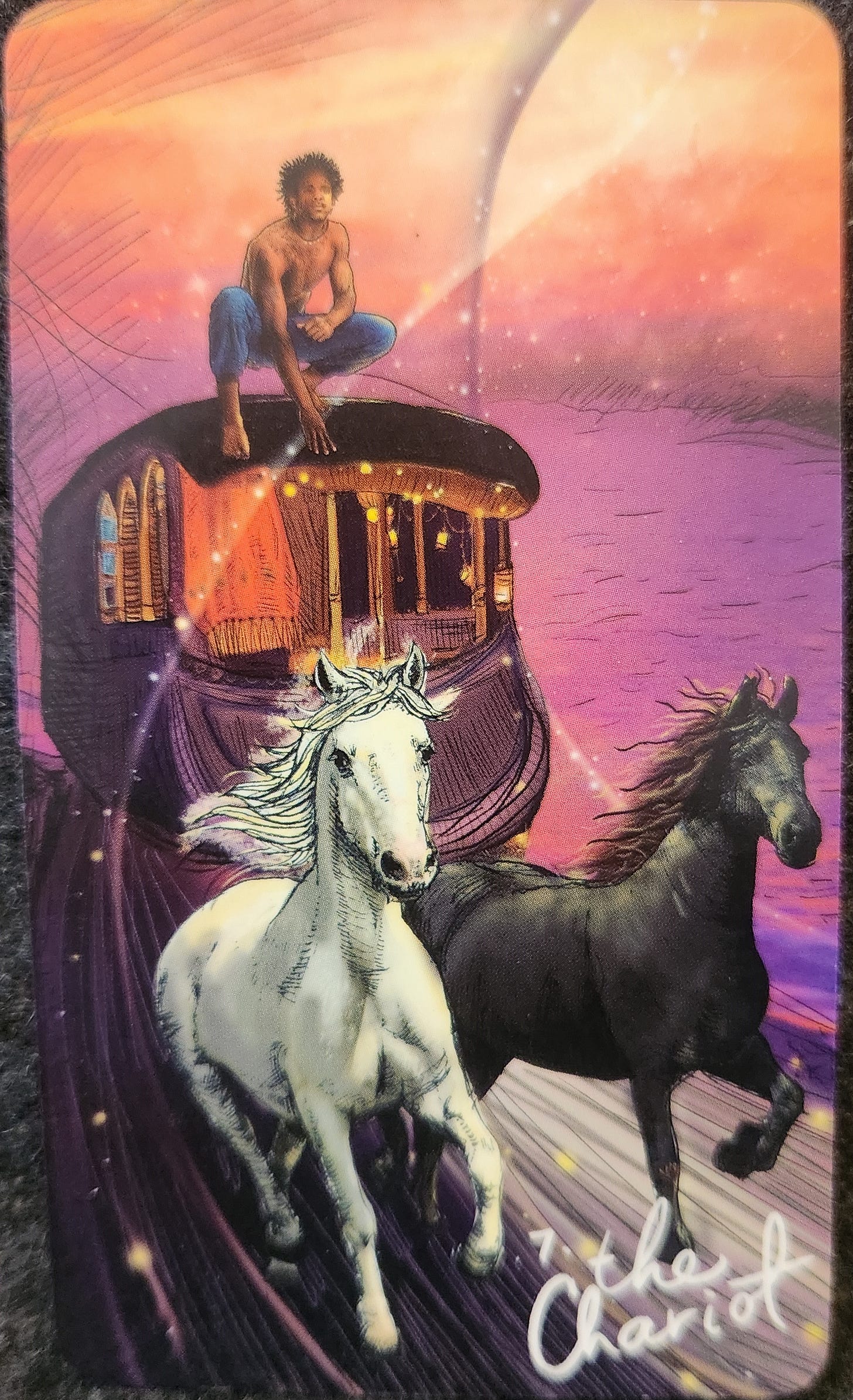 A tarot card labelled 7 The Chariot. A person sits kneeling on top of a carriage car. The carriage is being pulled by two horses, one black and one white. The horses are moving rapidly with determination. The person appears relaxed and confident, though they are not holding on to anything. Energy swirls around the carriage. 