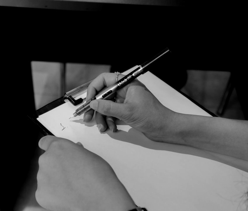 Hands writing on a clipboard with a pen. Hands writing on a clipboard with a pen.