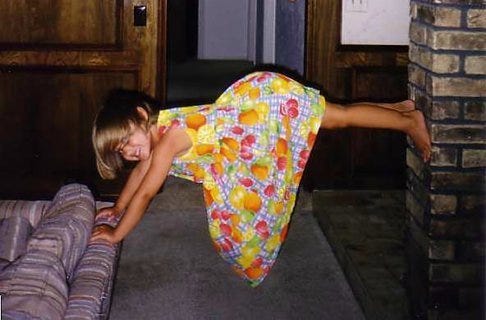 younger me making myself into a bridge between the couch and the brick column in my home