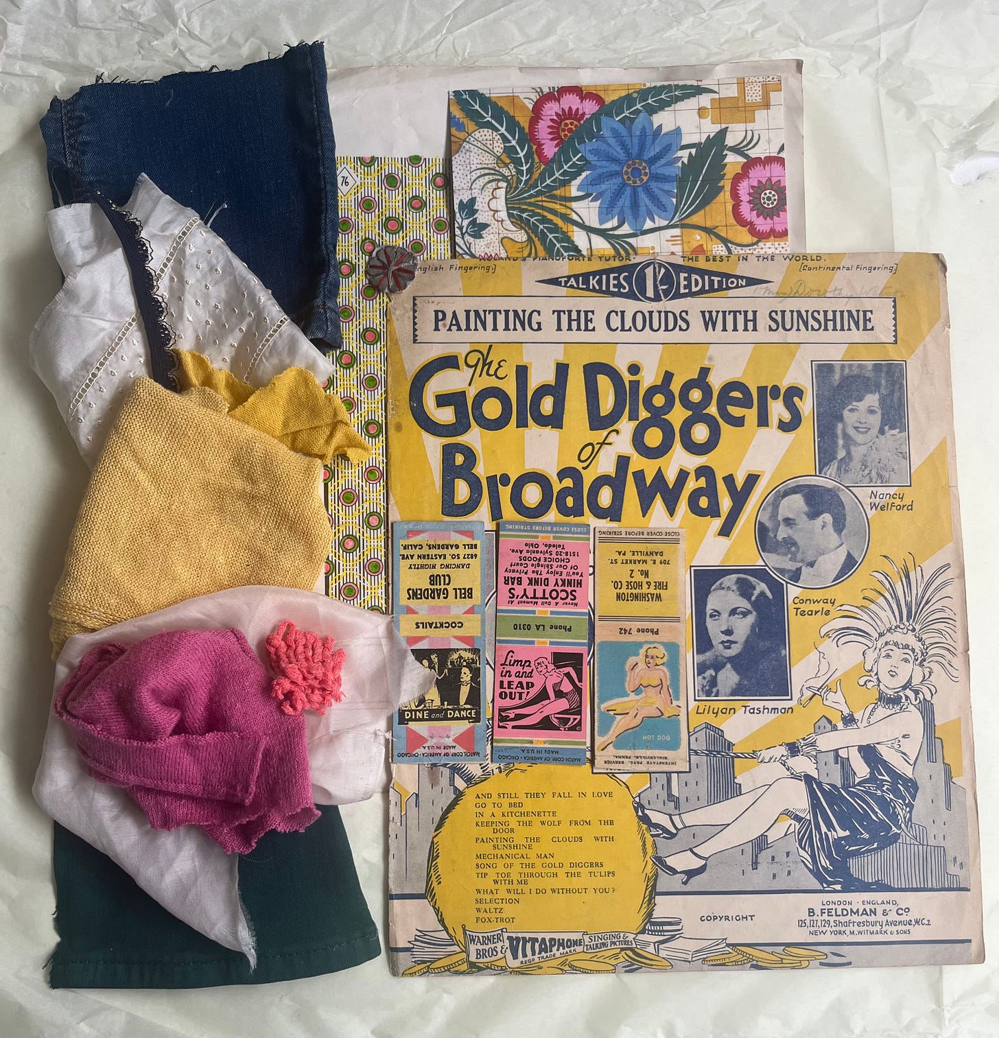 Moodboard featuring a vintage piece of sheet music. Great bold yellow stripes, indigo writing and  an illustration of a  glamorous showgirl. Around this is a floral postcard and then swatches of colour. Indigo, white, yellow, pink and dark green. It's fun and glamorous! 