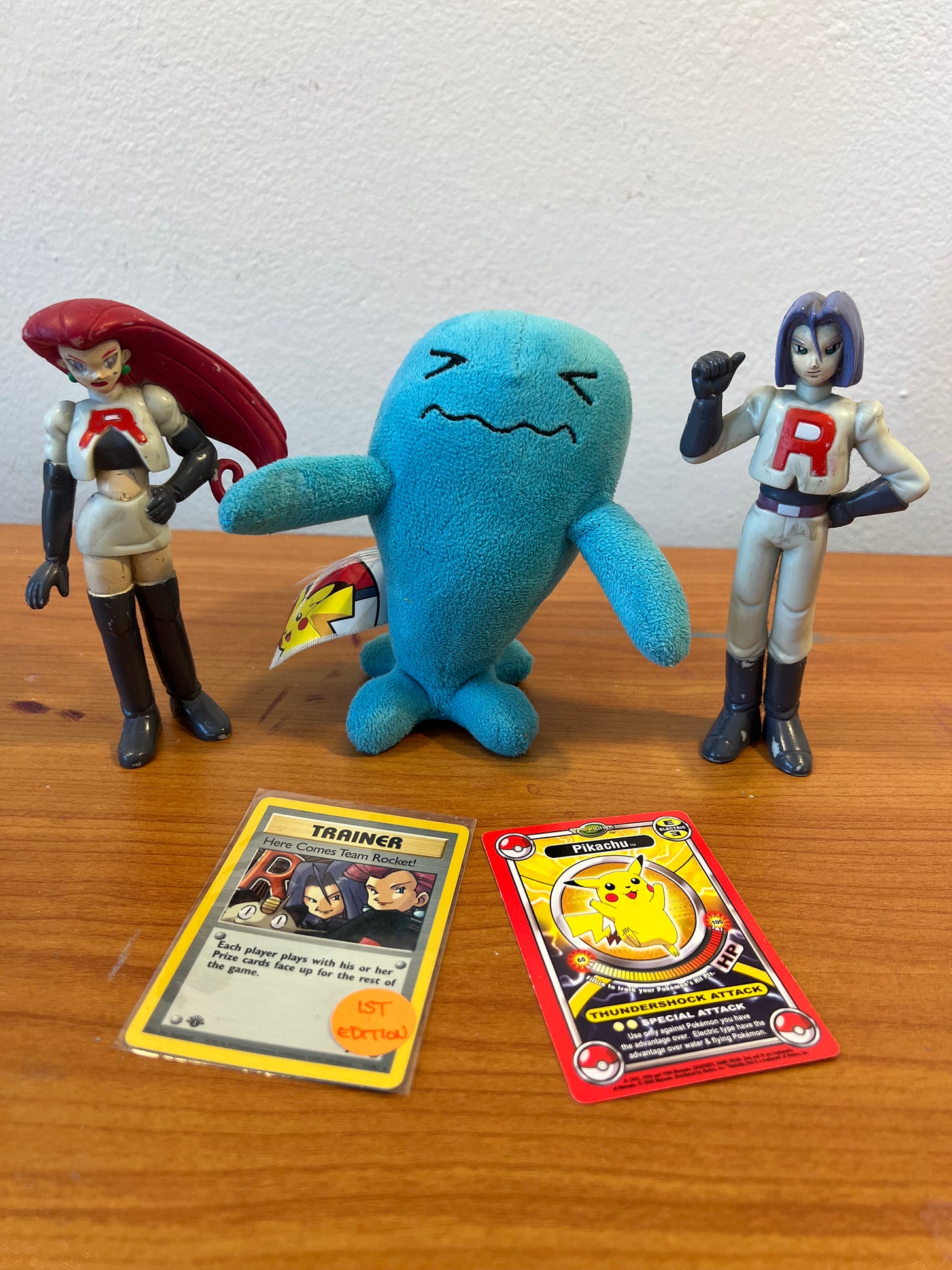 Shannon's treasured Pokémon items include figures of Jessie and James, a Here Comes Team Rocket! trading card, a ThinkChip Pikachu card, and a Wobbuffet plush toy