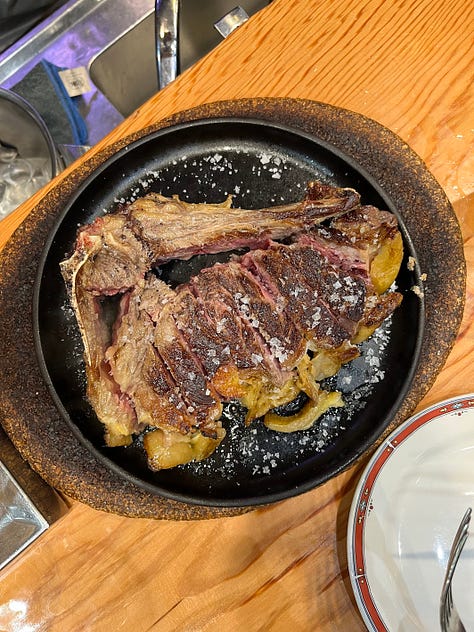 A Bar Nestor employee pouring cider into a glass, overhead shot of a tomato salad, over head shot of a cooked, sliced steak