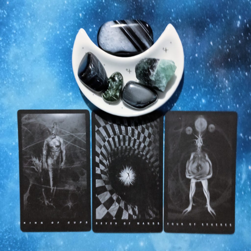 The Art of Not Losing It: A Message From the Universe, 3 Black Tarot cards and crystals on a starry blue background The Art of Not Losing It: A Message From the Universe, 3 Black Tarot cards and crystals on a starry blue background