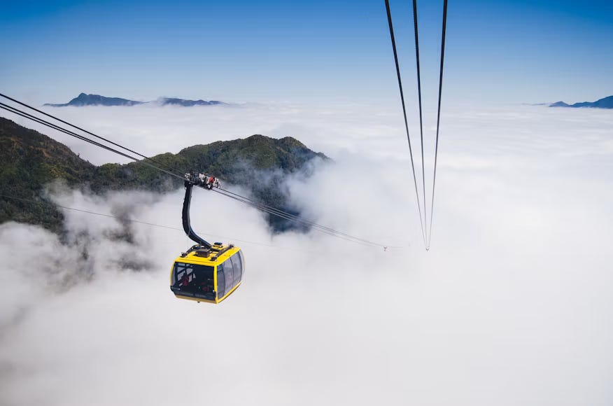 The cable car to Fansipan rises above Sa Pa’s mountainous landscape, with clouds stretching across the valleys below. The cable car to Fansipan rises above Sa Pa’s mountainous landscape, with clouds stretching across the valleys below.