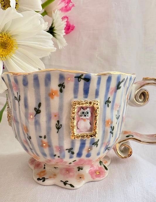 This may contain: a cup with an owl on it and flowers in the background