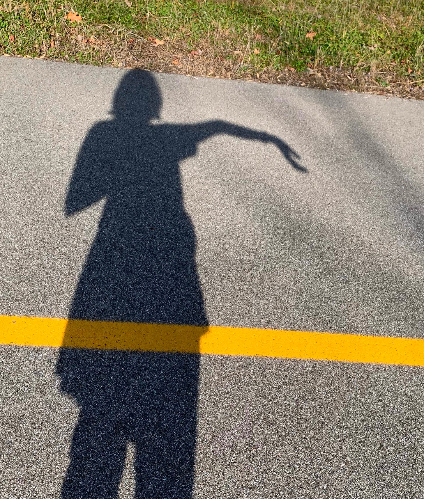The shadow of a woman with her arm extended and elbow bent past 180 degrees