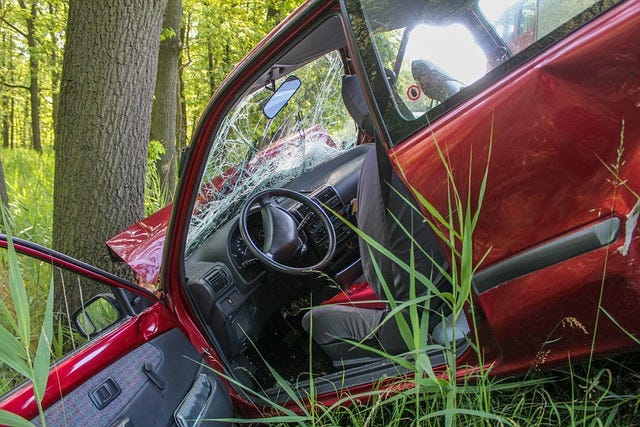 a red car that has crashed into a tree. Via Pixabay, in the public domain. 