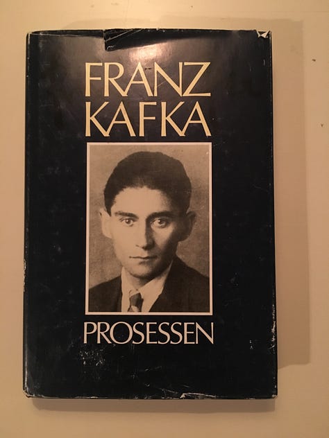 Photos show from left to right: the Franz Kafka book "The Process" in Norwegian, a bowl of soup and a piece of knekkebrød, and knotted tree trunks on a dark, wet street.