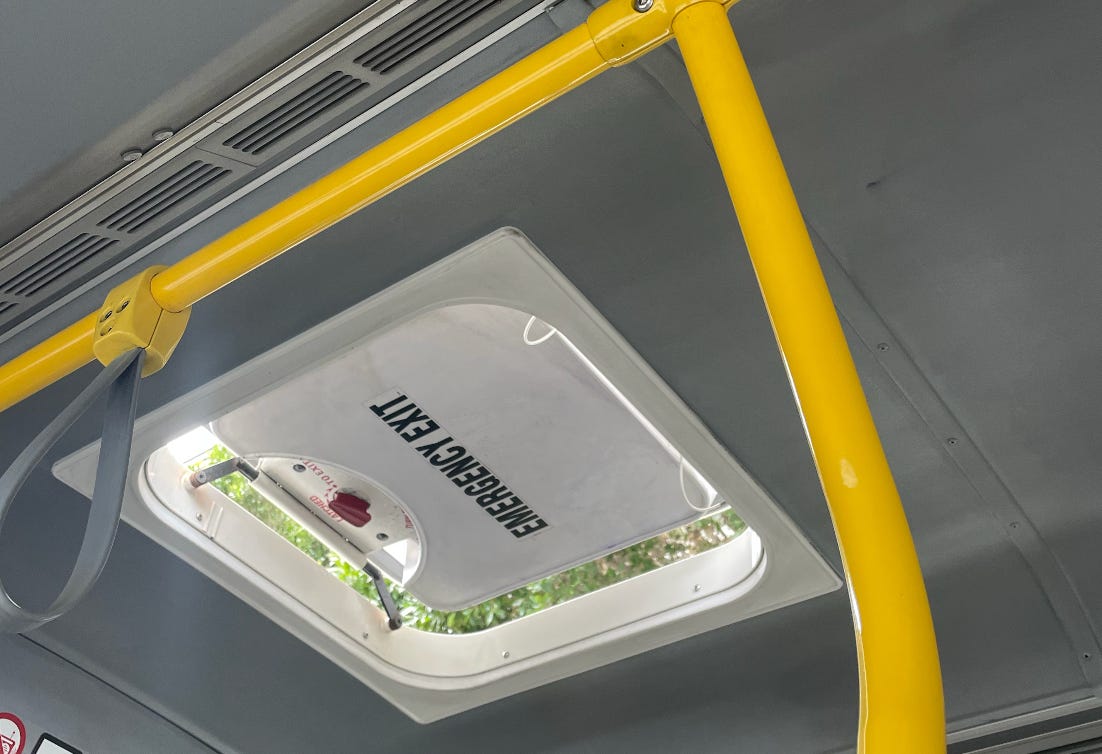 An emergency exit hatch on the roof of a bus.