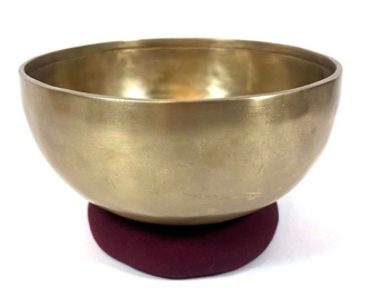 A brass bowl on a red cushion

Description automatically generated