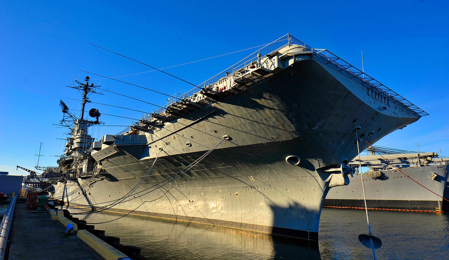 The retired aircraft carrier Hornet juts into the frame against a bright blue sky. The retired aircraft carrier Hornet juts into the frame against a bright blue sky.